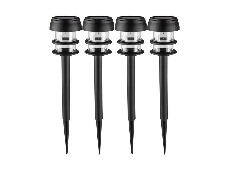 Quatre lampes de jardin solaires noires avec des lumières brillantes.