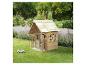Maisonnette en bois avec une petite voiture jouet dans un jardin vert.