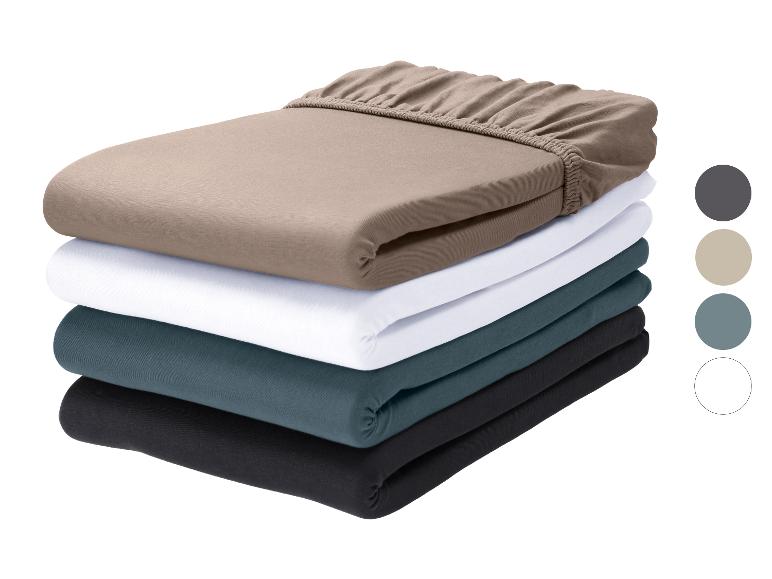 Draps-housses empilés en beige, blanc, turquoise et noir, avec des échantillons de couleurs à côté.