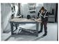 Homme en sweat-shirt haute visibilité PARKSIDE PERFORMANCE® perçant dans un atelier.