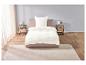 Draps blancs sur un lit avec deux tables de chevet.