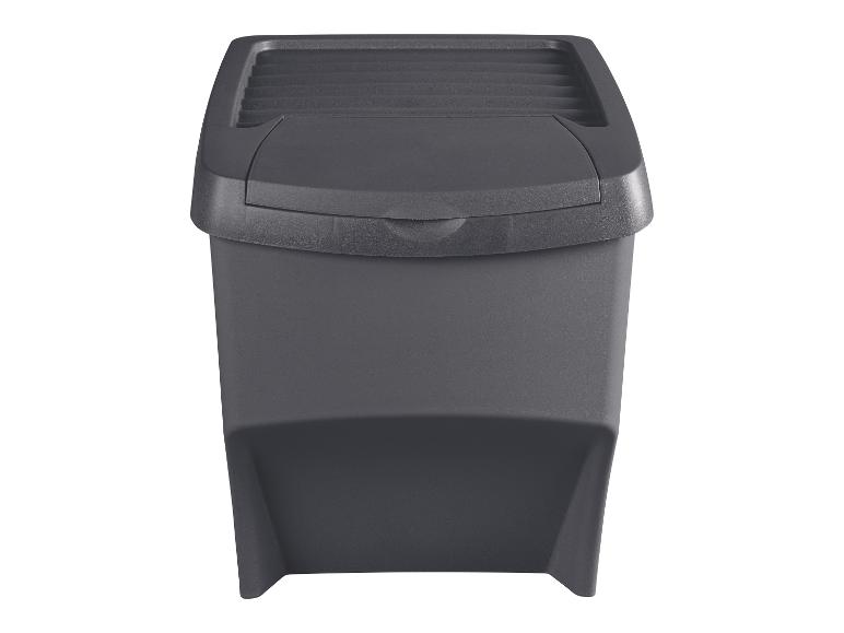Poubelle en plastique gris foncé avec couvercle basculant, isolée sur fond blanc.