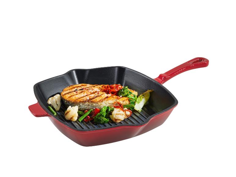 Saumon grillé avec légumes dans une poêle rouge.