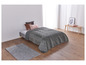 Une couette grise à motif géométrique sur un lit dans une chambre moderne.