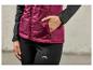 Une femme portant une veste rouge et un pantalon de jogging noir de la marque Craft.