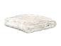 Une couette blanche matelassée pliée sur un fond blanc.