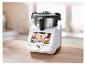 Robot de cuisine avec écran tactile affichant modes et recettes, sur une table en bois.