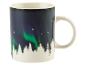 Une tasse avec une image d'aurores boréales au-dessus d'une forêt.