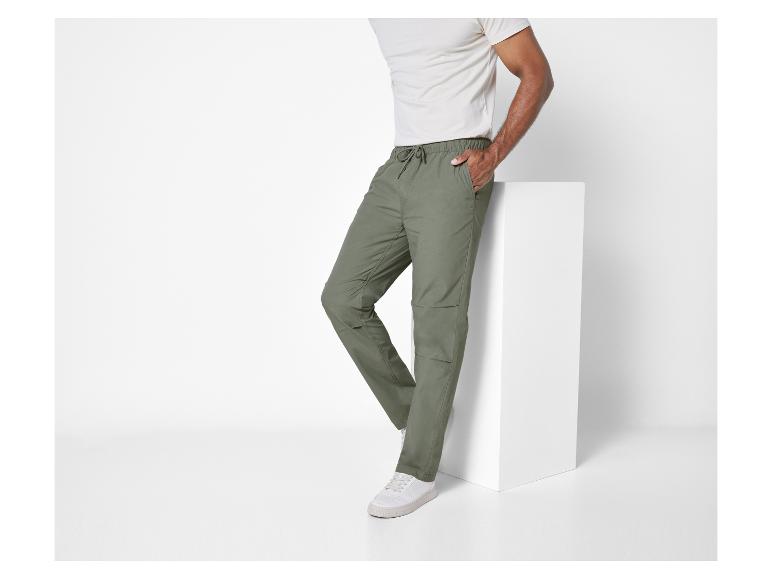 Un homme portant un pantalon vert et des baskets blanches.