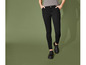 Pantalon noir et chaussures noires sur un fond vert.