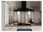 Cuisine moderne avec hotte noire, plaque à induction, four et plan de travail en bois.