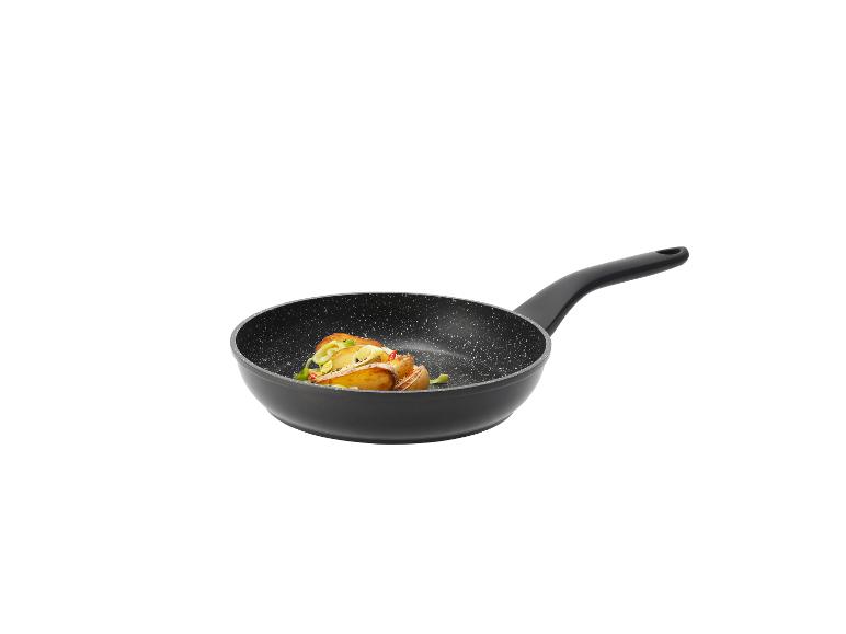 Poêle à frire noire avec des pommes de terre rôties et des légumes