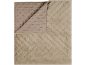 Jeté de lit beige matelassé à motif losanges, plié pour montrer le dessous.