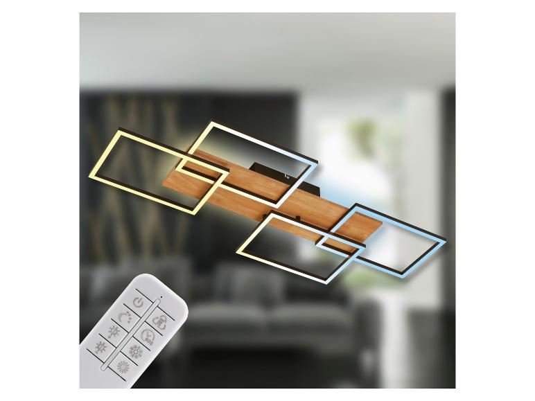 Plafonnier LED moderne avec éléments en bois et télécommande, éclairant une pièce floue.