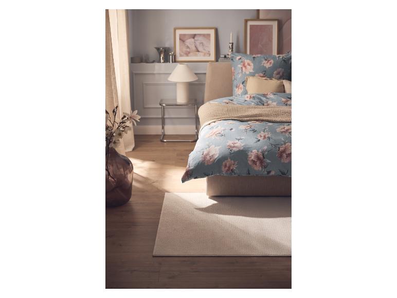 Tapis clair LIVARNO home sous le lit dans la chambre.