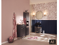 Salle de bain moderne avec meubles gris, lavabo noir, miroir rond et papier peint floral.
