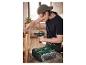 Un homme utilise une perceuse-visseuse Parkside et une boîte à outils pour assembler du bois.