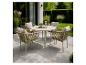Ensemble de salle à manger d'extérieur avec table ronde et quatre chaises sur une terrasse avec plantes de jardin.