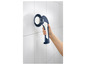 Une brosse de nettoyage bleue avec une poignée pour nettoyer les carreaux.