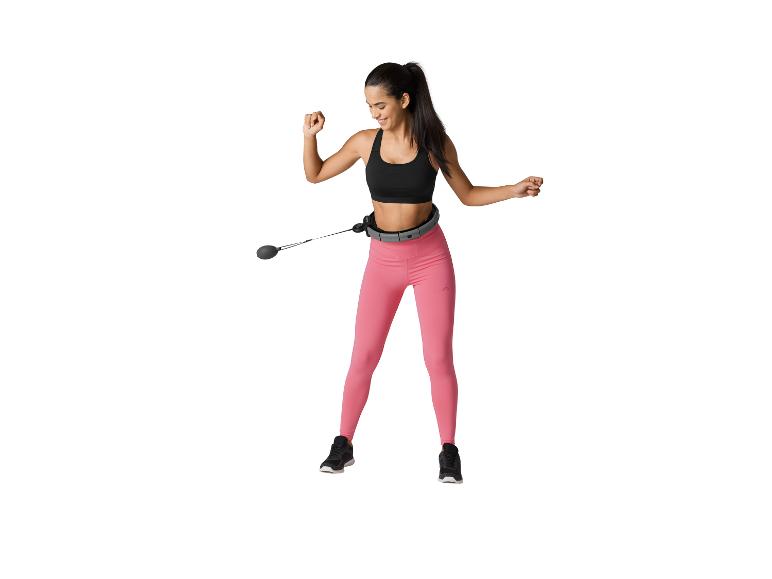 Femme souriante portant un cerceau intelligent et un legging rose.