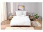 Draps blancs, tables de chevet et tapis minimalistes dans une chambre à coucher.