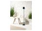Lampe sur pied design et fauteuil moderne avec plantes vertes.
