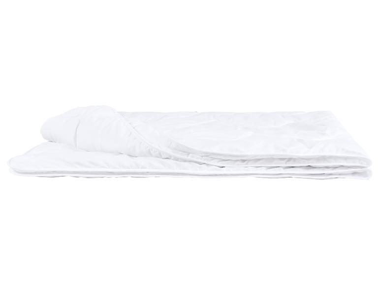 Couette blanche pliée avec matelassage sur fond blanc