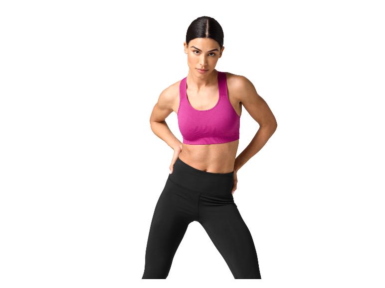 Femme en brassière de sport fuchsia et leggings noirs