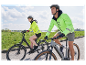 Deux cyclistes en vêtements Decathlon font du vélo électrique.