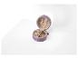 Un coffret à bijoux en velours violet avec des bagues et des boucles d'oreilles dorées.