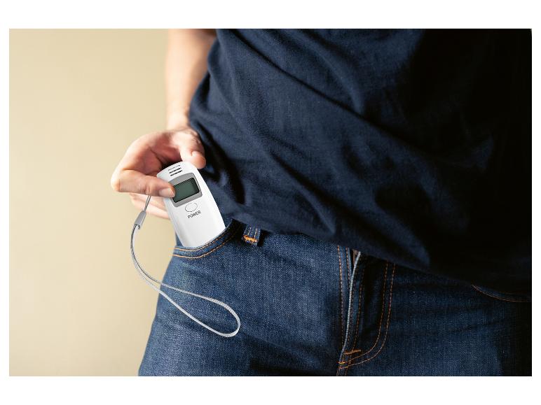 Une personne sort un éthylotest blanc de sa poche.