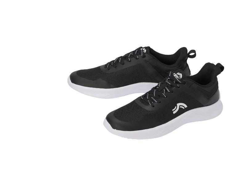 Paire de chaussures de sport noires avec semelles blanches et lacets à motifs blancs.