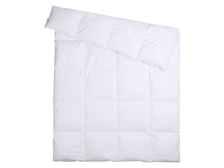 Couette blanche avec oreiller, pliée en diagonale