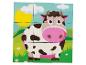 Puzzle en bois avec une vache dans un champ vert.