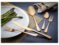 Couverts en or rose avec un couteau, une fourchette et une cuillère sur une assiette avec des asperges.