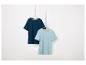 Deux t-shirts unis, bleu marine et bleu clair, suspendus à des cintres.