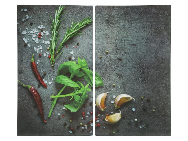 Deux planches à découper avec des herbes, des épices et de l'ail.