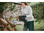Femme utilisant une tronçonneuse Parkside pour couper des bûches sur un tréteau en bois.