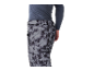 Homme en pantalon de ski gris à motifs et maillot thermique bleu foncé.