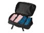 Un sac de voyage noir avec une chemise rose et un jean bleu.