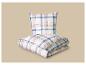 Oreiller et couette pliée à carreaux bleus et blancs sur fond beige.