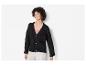 Une femme porte un cardigan noir en tricot à boutons.
