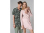 Un homme et une femme en tenue décontractée, il porte une chemise camouflage et elle une robe rose.