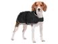 Un beagle portant un manteau noir pour chien, debout sur un fond blanc.