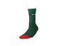 Chaussette verte avec pointe et talon rouges, ornée d'un motif géométrique.