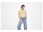 Femme en t-shirt jaune à manches courtes et jean ample.