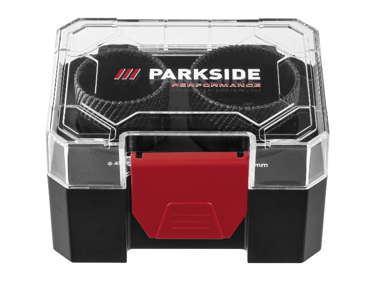 Une boîte de rangement en plastique noir et transparent avec un loquet rouge, contenant deux disques abrasifs noirs.