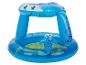 Piscine gonflable bleue pour enfants avec auvent en forme de requin et décorations marines.