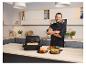 Chef masculin dans une cuisine à côté d'une friteuse Philips et de lasagnes.