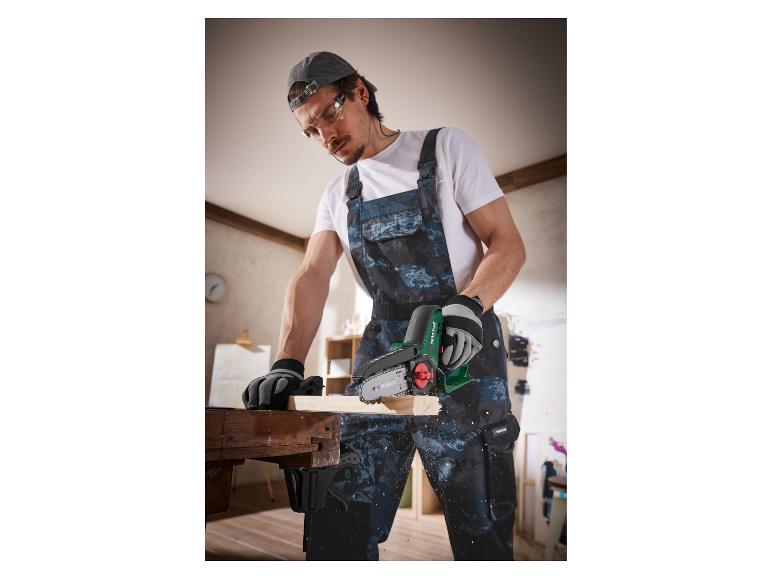 Un homme utilise une scie à chaîne Parkside pour couper du bois.